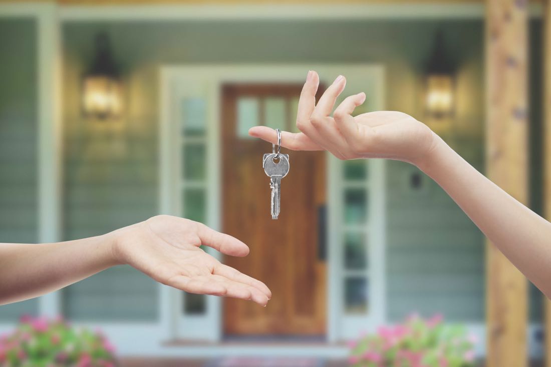 Tenant receiving keys to their new Australian rental property from a real estate agent